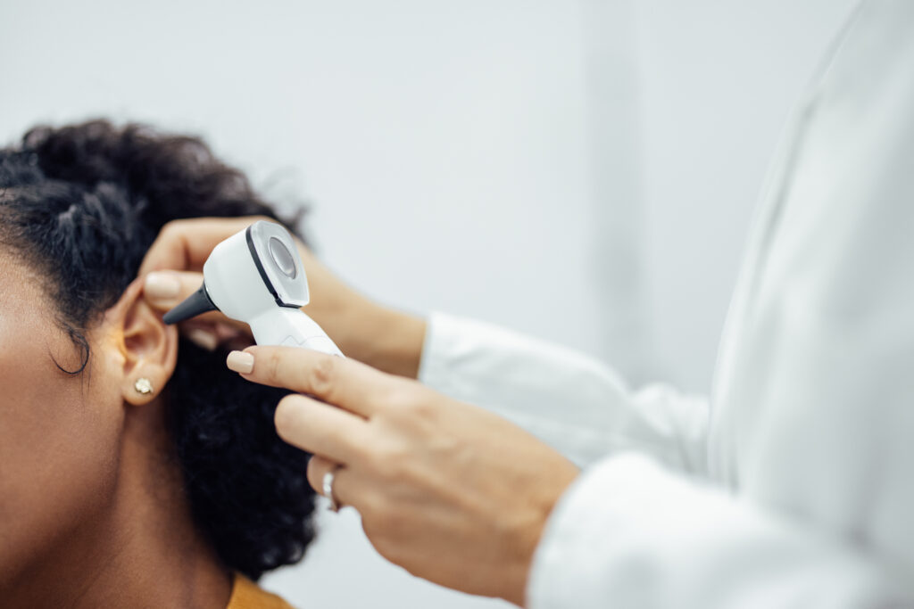 dottore esamina orecchie a sventola di una paziente 